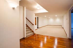 Finished basement with stairs and hardwood floors.
