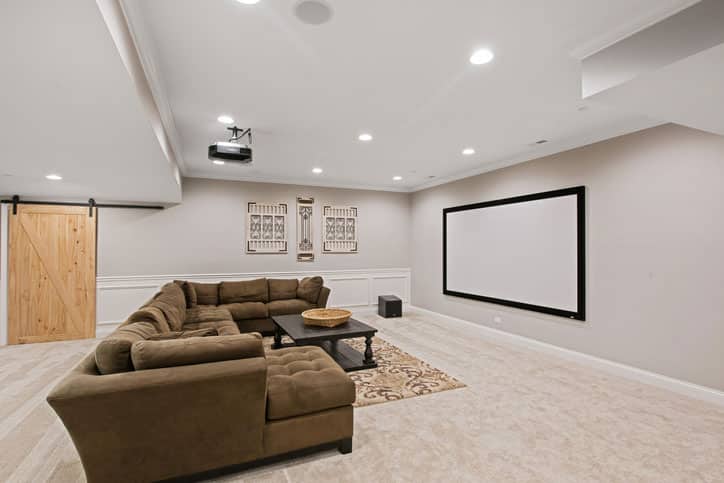 Projector screen and comfortable seating in spacious basement room