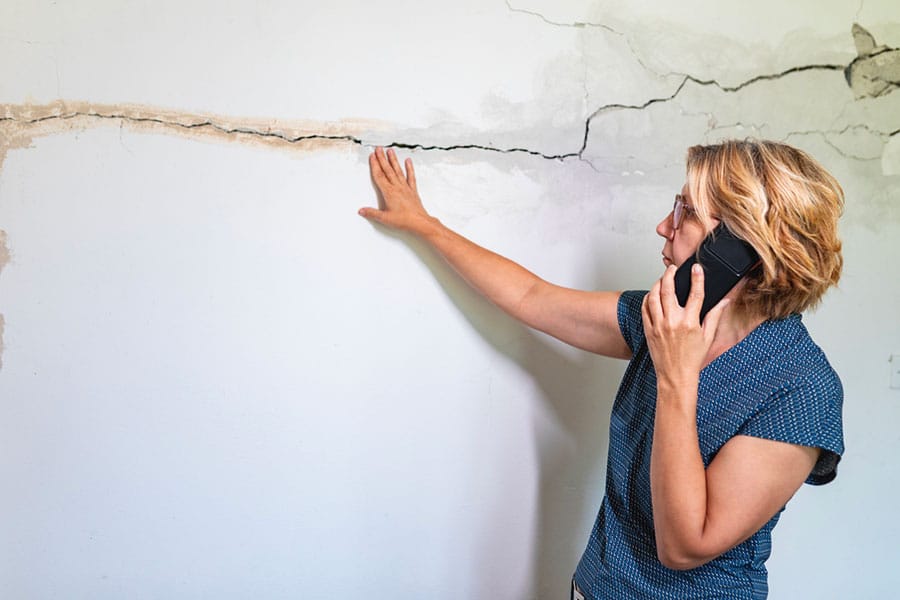 Woman Looking at Cracked wall